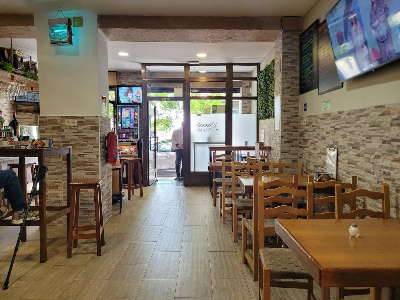 Barra y mesas del local, con la entrada al fondo
